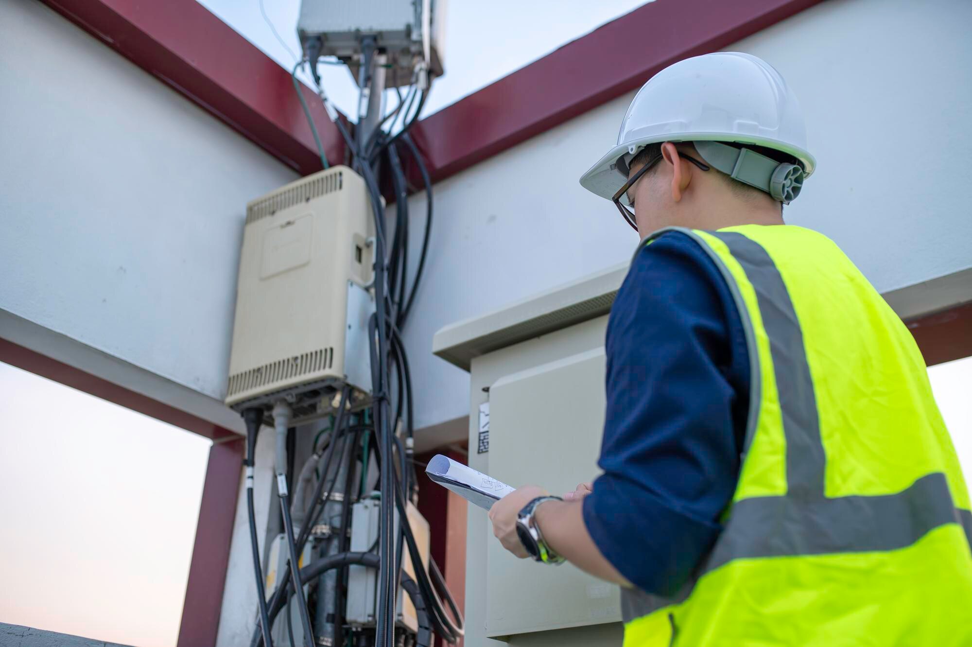 WZC field engineers reviewing plans at the base of a lattice communications tower
